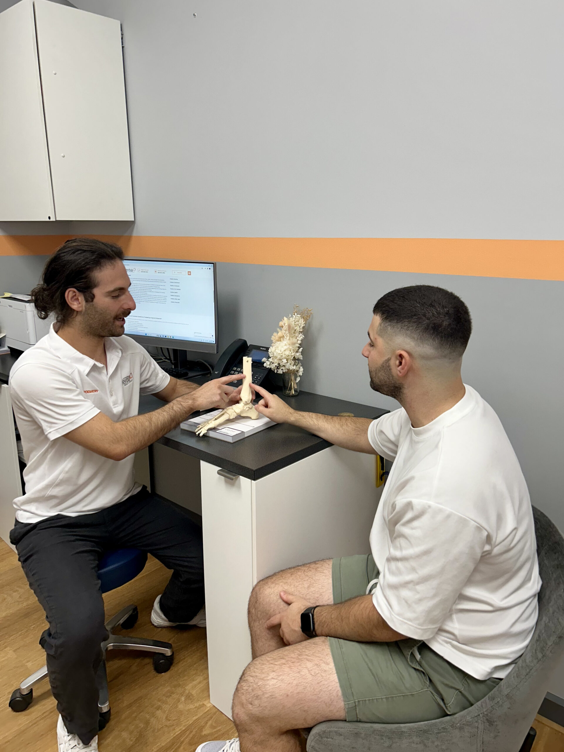 A podiatrist educates his patient about foot health in a clinical setting at Inertia Health Group's Port Adelaide clinic