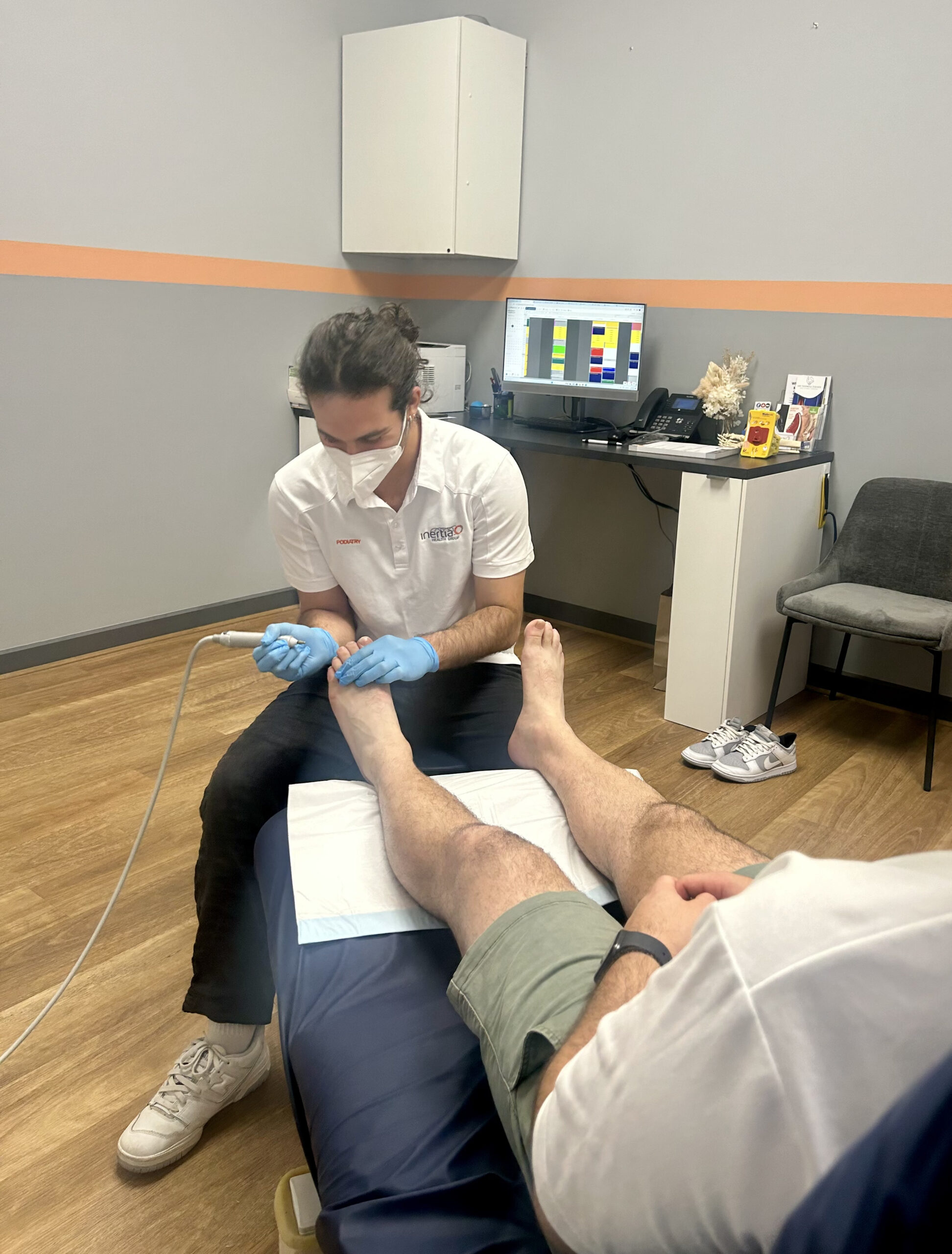 A podiatrist meticulously treats his patient's foot at a podiatry clinic in Port Adelaide, South Australia