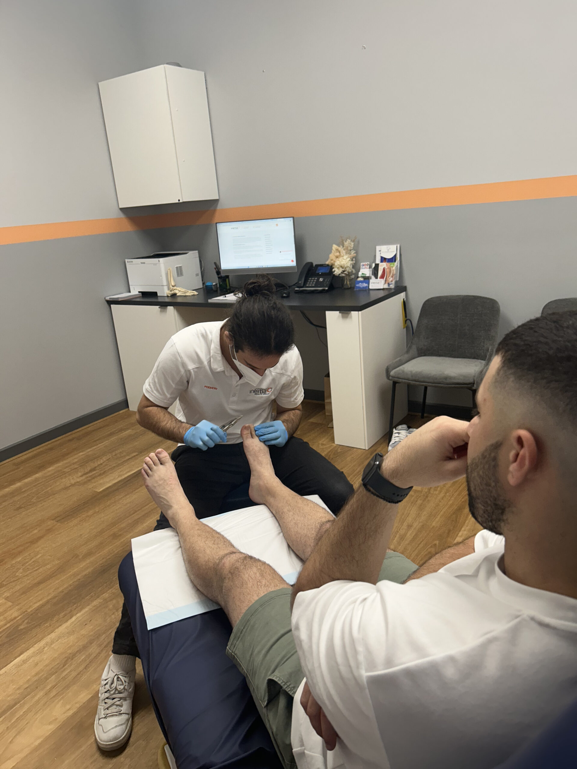 A podiatrist conducts a detailed examination of a patient's foot in a clinical setting.