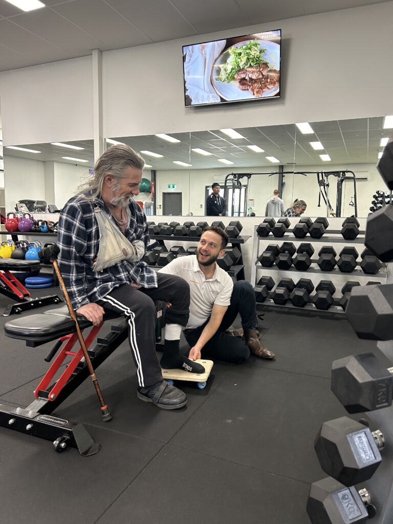 An injured man receiving physiotherapy treatment from a physiotherapist