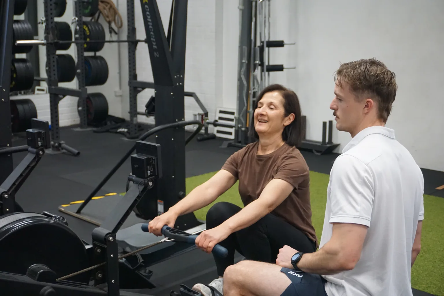 Physio Grange session at Inertia Health Group with a physiotherapist guiding a client using gym equipment for rehabilitation and physiotherapy.