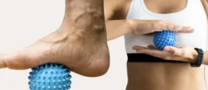 A person using a trigger ball on the sole of their foot, a physio technique for relieving muscle tension and plantar pain.