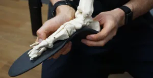 Podiatry professional explaining how custom orthotics support foot alignment and movement