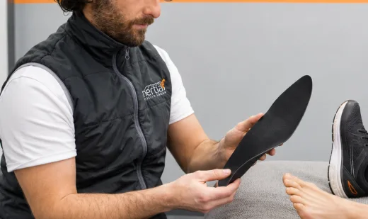 Podiatry specialist fitting custom foot orthotics to improve comfort, support and mobility