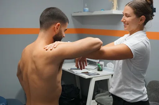 Physiotherapist providing treatment for frozen shoulder to improve shoulder movement