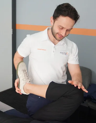 Physiotherapist stretching a patient's leg to help relieve tight muscles